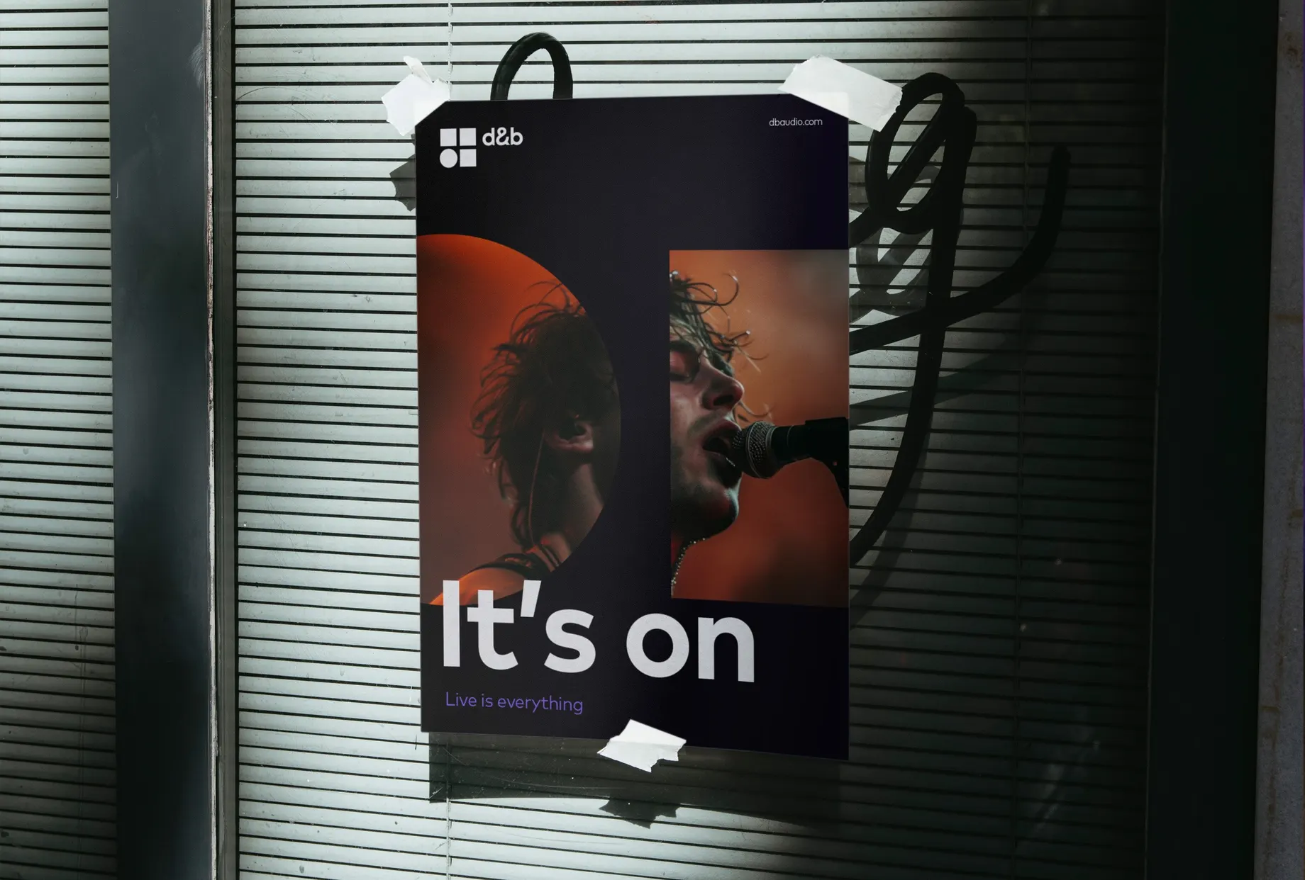 Plakat, mit Klebestreifen an einem Rollladen befestigt: ein singender Musiker am Mikrofon in orangem Licht, dazu in grossen Lettern „It’s on“ und der Claim „Live is everything“.