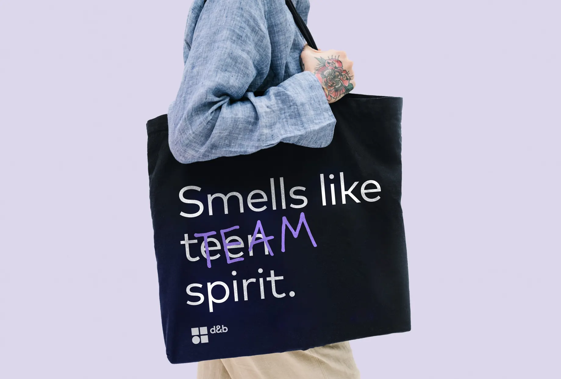 Schwarze Stofftasche mit dem Aufdruck „Smells like TEAM spirit.“ und dem d&b-Logo, über der Schulter getragen.