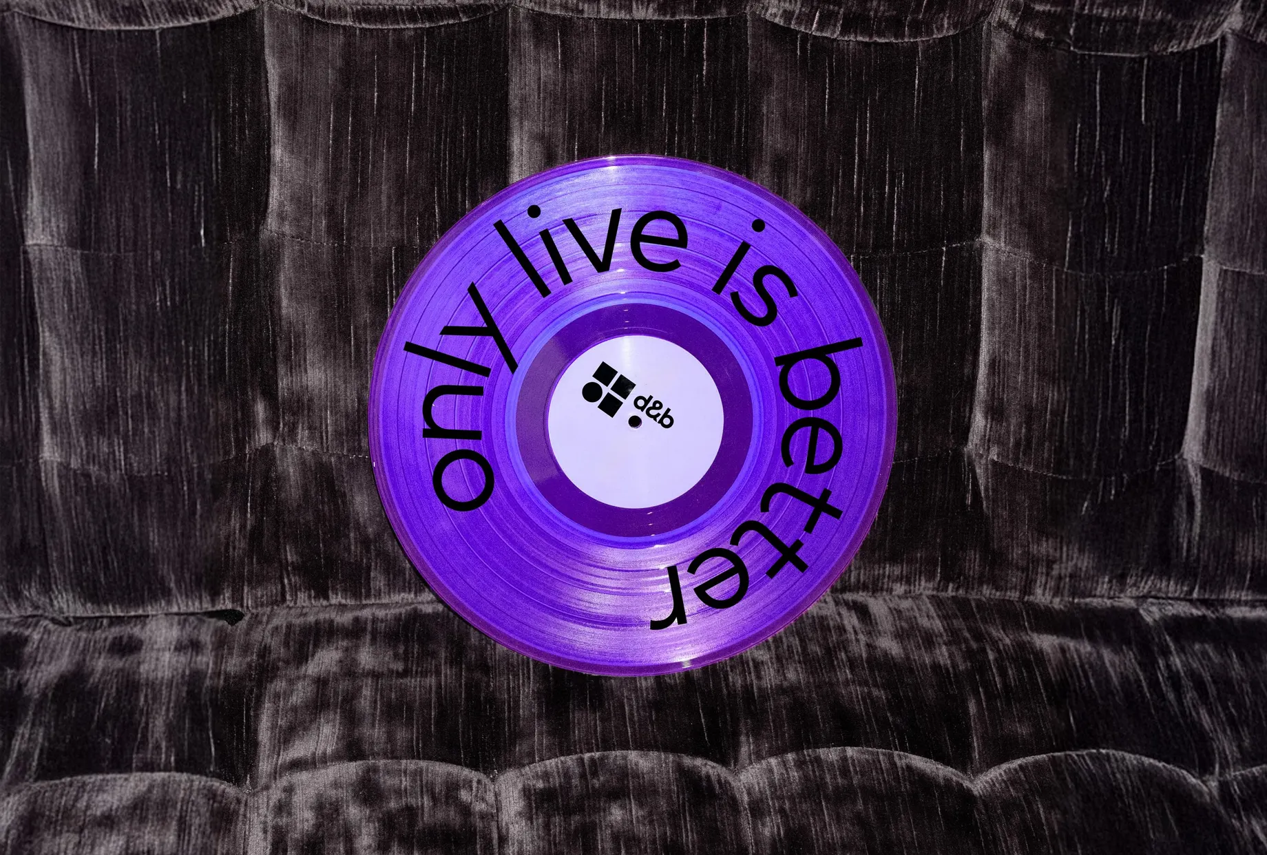 Violette Schallplatte mit dem Schriftzug „only live is better“ rund um das Label und dem d&b-Logo in der Mitte.