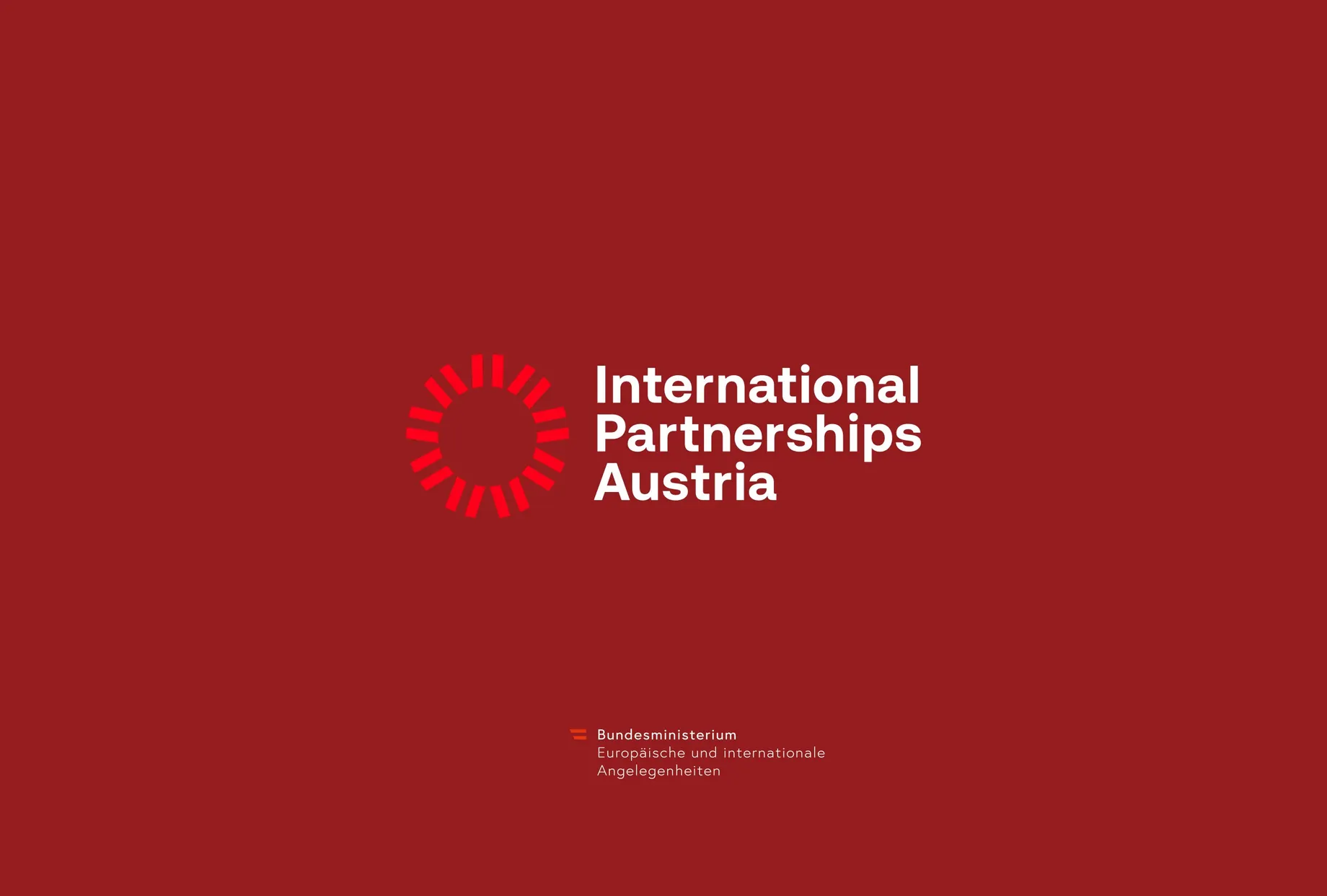 Logo „International Partnerships Austria“ in Weiss auf dunkelrotem Grund, links davon ein Kreis aus roten Strahlen. Darunter die Absenderzeile des Bundesministeriums für europäische und internationale Angelegenheiten.