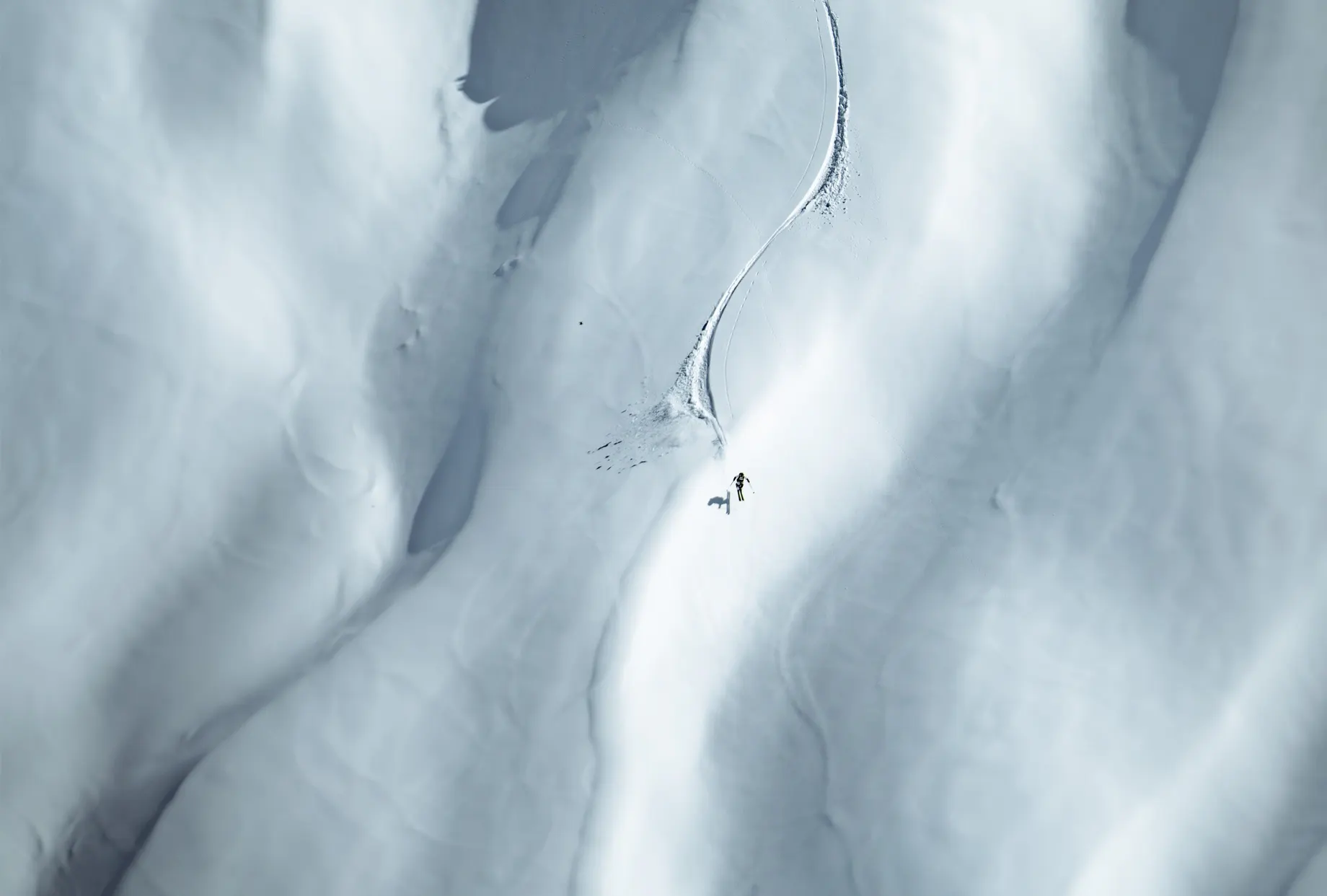 Ein Skifahrer in voller Fahrt auf einem verschneiten Berghang, dynamisch in Szene gesetzt mit Kästle Skiern, die für Präzision und Performance stehen.